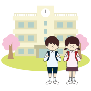 桜の咲く小学校の前で立つ新入生